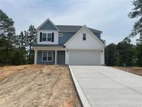 Two-story home featuring blue and white accents, a two-car garage, and a concrete driveway at 39 Tackett Ct, Lillington, NC 27546