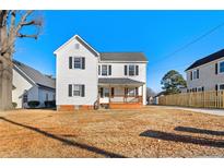 Two-story house with white siding, a brick base, and a small front porch at 107 N 12Th St, Erwin, NC 28339