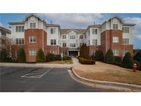 Spacious brick and white condo building with lush landscaping and an inviting entrance at 1222 Waterford Lake Dr, Cary, NC 27519