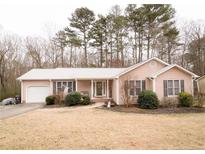 Ranch style house with a pink exterior, landscaped yard, and attached garage at 334 Brookfield Cir, Sanford, NC 27330