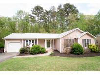 Charming ranch-style home featuring a well-manicured lawn, mature landscaping, and an attached garage at 334 Brookfield Cir, Sanford, NC 27330