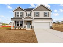 Two-story house with gray siding, stone accents, and a two-car garage at 38 Steeple Rdg, Cameron, NC 28326