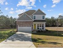 Charming two-story home boasts brick accents, a two-car garage, and a welcoming front porch at 501 Stadium Dr, Cameron, NC 28326
