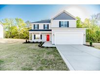 Charming two-story home with a red front door, well-manicured lawn, and a spacious two-car garage at 87 Onslow Ct, Spring Lake, NC 28390