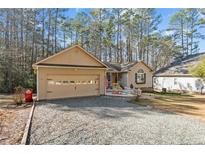 Ranch home with gravel driveway and mature trees at 1345 Ohio Ln, Sanford, NC 27332