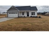 Charming single-story home with a two-car garage and well-maintained lawn at 135 Jones Creek Ln, Lillington, NC 27546