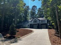 Two-story home with a wraparound deck, two-car garage, and landscaped yard at 15 The Pointe, Sanford, NC 27332