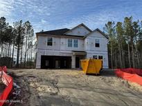 New construction featuring a two-story home with an attached garage, set in a wooded lot during the building phase at 36 Horse Trot Ln, Sanford, NC 27330
