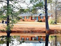 Brick ranch home with a pond view, showcasing a tranquil setting at 207 Mcleod Dr, Sanford, NC 27330