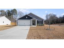 Two-toned house with a white garage door and landscaping at 216 Barnsley Rd, Angier, NC 27501