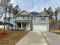 Charming two-story home features a two-car garage, covered porch, and a well-manicured lawn at 44 Horse Trot Ln, Sanford, NC 27332