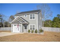 Charming two-story home with gray siding, a black door, an American flag, and a well-maintained front yard at 206 Westpark Ln, Sanford, NC 27332