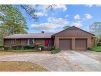 Charming brick home featuring a two-car garage, a red front door, and mature landscaping at 48 Indian Trl, Sanford, NC 27332