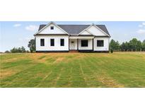 Charming single-story home with white siding, black trim, and a spacious front yard at 541 Delma Grimes Rd, Coats, NC 27521