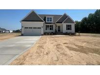 Charming two-story home featuring a two-car garage and a well-manicured lawn at 55 Councel Williams Rd, Coats, NC 27521