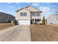 Charming two-story home featuring a two-car garage, manicured lawn, and welcoming curb appeal at 539 Botanical Ct, Bunnlevel, NC 28323