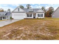 White house with two-car garage and well-maintained lawn at 136 Parkview Ln, Lillington, NC 27546