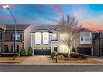 Two-story home with gray siding, black garage doors, and landscaping at 4008 Windflower Ln, Raleigh, NC 27612