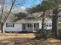 Ranch style home with white siding, covered porch, and mature trees at 885 Dry Creek Rd, Lillington, NC 27546