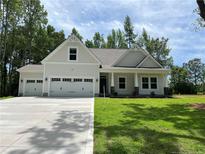 Beautiful one-story home with a three car garage and a well-manicured lawn at 42 Peach Orchard (Lot 2) Ln, Lillington, NC 27546
