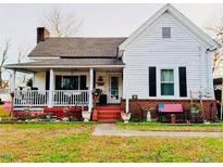 Charming white farmhouse with a spacious front porch and well-maintained lawn at 305 W K St, Erwin, NC 28339