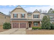 Charming two-story home featuring a brick facade, two-car garage and manicured landscaping at 323 River Oak St, Spring Lake, NC 28390