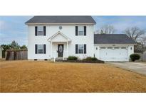 Charming two-story home featuring a well-manicured lawn and an attached two-car garage at 86 Carolina Oaks Cir, Linden, NC 28356