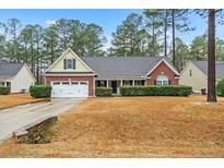 Charming one-story home featuring a brick facade, manicured landscaping, and a two-car garage at 90 Orchard Falls Dr, Spring Lake, NC 28390