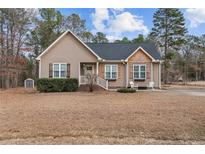 Charming one-story home featuring a cozy front porch and well-maintained landscaping at 104 Exie Pl, Lillington, NC 27546