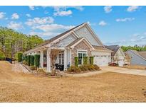 Charming single-story home featuring stone accents, a manicured lawn, and an attached two-car garage at 15 Glenwood Ct, Spring Lake, NC 28390