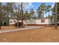 Charming single-story home features a spacious yard, attached garage, and inviting front porch at 16 Summer Breeze Ct, Cameron, NC 28326