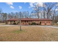 Charming brick ranch-style home with an attached two-car garage and a welcoming front yard at 1916 Carr Creek Rd, Sanford, NC 27332