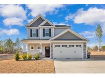 Charming two-story home featuring a two-car garage, stone accents, and beautifully landscaped front yard at 2538 Marks Rd, Cameron, NC 28326