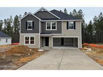 Two-story home featuring a two-car garage and charming curb appeal on a cloudy day at 288 Rocking Horse Ln, Sanford, NC 27332