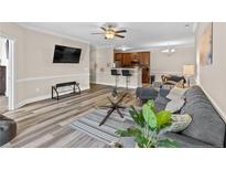 Inviting living room featuring hardwood floors, a ceiling fan, and a breakfast bar into the kitchen at 291 Gallery Dr # 202, Spring Lake, NC 28390