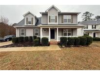 Charming two-story home with light gray siding, a cozy front porch, and well-maintained landscaping at 216 Cobblestone Dr, Spring Lake, NC 28390