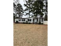 Cozy one story home with white siding, a lawn, and mature trees at 22176 Nc 24-27, Cameron, NC 28326