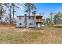 Charming two-story home with gray siding, stone accents, and a cozy upper level balcony at 4454 Wire Rd, Linden, NC 28356