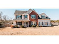 Charming two-story home featuring a mix of brick and siding, complemented by a well-manicured lawn at 45 Trail Rider Ln, Sanford, NC 27332