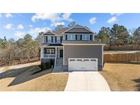 Charming two-story home with a welcoming front porch and a two car garage at 48 Cedarview Ct, Cameron, NC 28326