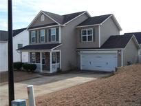 Two-story home with tan siding, covered porch, attached garage, and well-maintained front yard at 96 Boston Hbr, Cameron, NC 28326