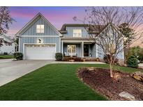 Charming two-story home with a well-manicured lawn, inviting front porch, and attached garage at 405 Clovermist Ct, Sanford, NC 27330