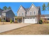 Charming two-story home featuring a two-car garage and a cozy front porch at 525 Falls Creek Dr, Spring Lake, NC 28390