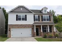 Charming two-story home with a brick and siding exterior, attached two-car garage, and a well-manicured front lawn at 115 David Hill Dr, Sanford, NC 27330