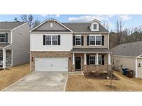 Charming two-story home featuring brick and siding exterior with attached two car garage and a well-maintained front yard at 115 David Hill Dr, Sanford, NC 27330