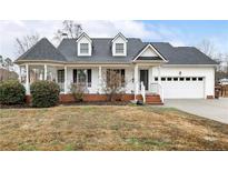 Charming one-story home with white siding, covered porch, attached garage, and well-maintained landscaping at 220 Waters Edge Dr, Erwin, NC 28339