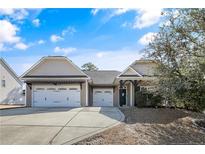 Charming home featuring a three-car garage, neutral siding, dark wood pergola and a well-manicured front yard at 31 Laurel Dr, Spring Lake, NC 28390