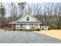 Charming home featuring a cozy front porch, a well-maintained yard, and a separate storage shed at 3208 Westchester Dr, Sanford, NC 27330