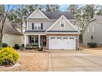 Charming two-story home with a well-manicured front yard and a welcoming front porch swing at 929 Micahs N Way, Spring Lake, NC 28390