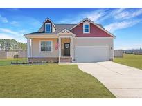 Charming two-story home with a manicured lawn, attached garage, and classic American flag display at 95 Southern Pl, Lillington, NC 27546